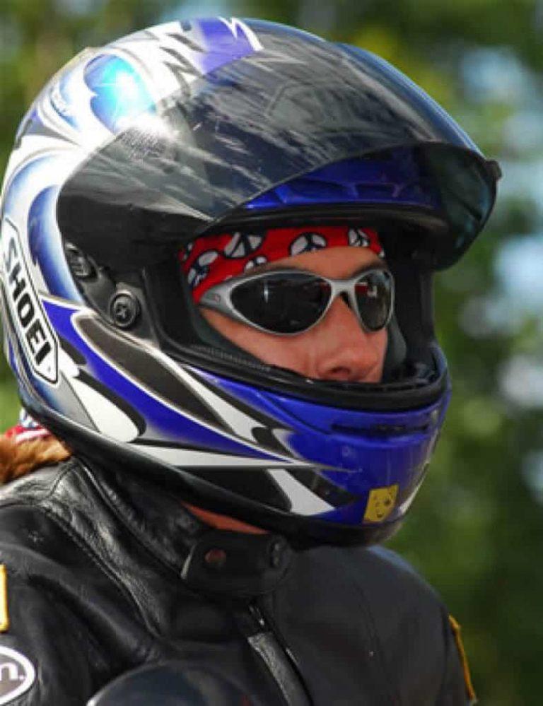 A portrait shot of a female motorcycle rider wearing a full face helmet. Kath is wearing a Original Buff® as helmet liner. She is also wearing a motorcycle leather jacket and sunglasses. Source: Kath Salotti © permission to use on our websites