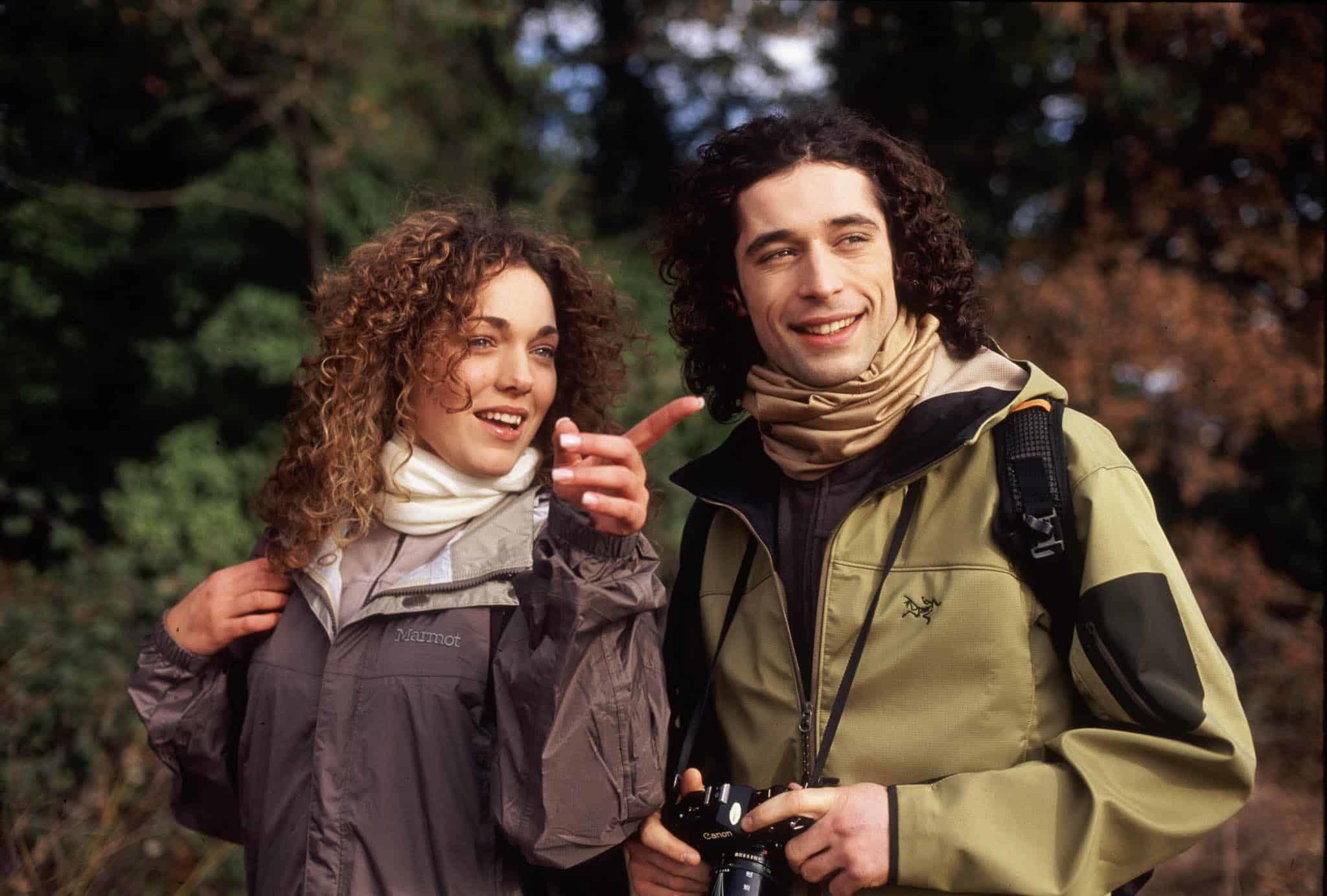 A couple in outdoor clothing during a hike. It looks cold and they are both wearing BUFF® Merino Lightweight multifunctional headwear as scarves. Source: buff.eu