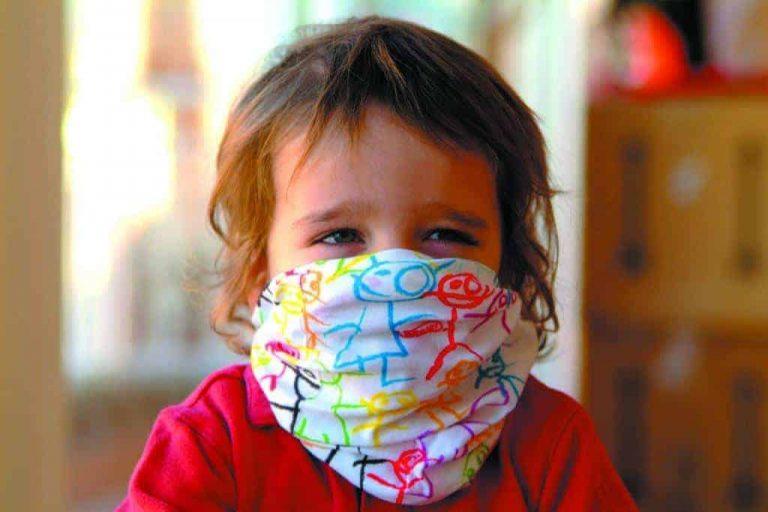 A toddler wearing a Baby Buff® as a face mask. The toddler looks happy. Source: buff.eu