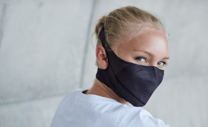 A woman in her 20's wearing a BUFF® Filter Face Mask and looking in the camera. You can see how the face mask perfectly fits the contour of her face. Source: buff.eu