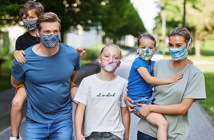 A young family with 3 kids wearing BUFF® Filter Masks in a park setting. Source: buff.eu