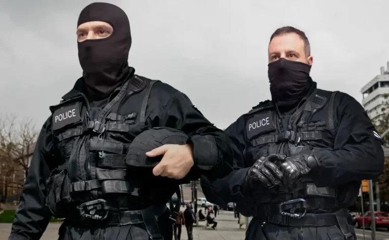 The image shows to police officers in black tactical gear wearing the BUFF® Safety Balaclava Modacryl FR. The officer on the left is wearing it as intended as a balaclava. The office on the right is wearing it as a facemask. Source: buff.eu