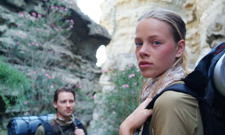 A cropped image of a couple hiking. The woman in the foreground is wearing a slim fit sized BUFF® headwear. Source: buff.eu